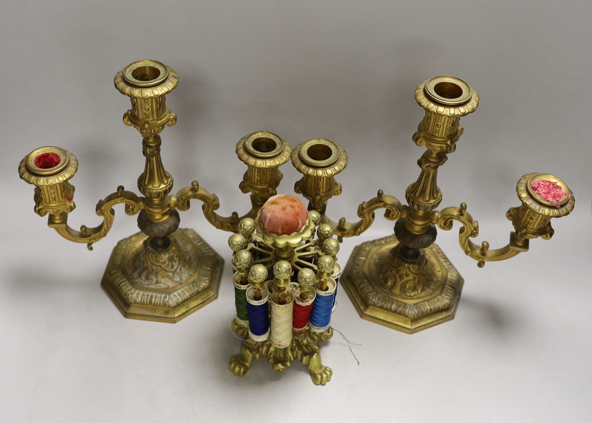 A pair of two branch three light gilt bronze candelabra and a brass cotton reel holder, candelabra 24cms high